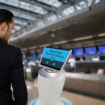 Smart robotic technology concept, The passenger follow a service robot to a counter check in in airport, the robot can help and give some information to passenger quickly
