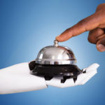 Close-up Of A Person Ringing Service Bell Hold By Robot Against Blue Background