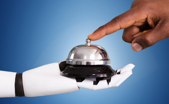 Close-up Of A Person Ringing Service Bell Hold By Robot Against Blue Background
